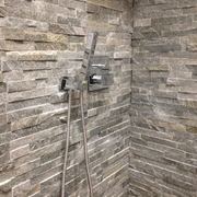 Pareti con rivestimento effetto pietra in una doccia moderna