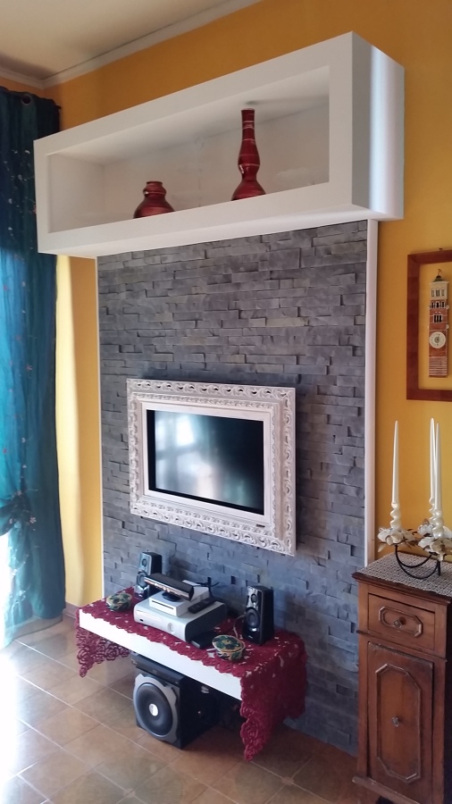 Foto: con rivestimento in pietra in gesso,e cornice in legno. di ... Parete in pietra con tv