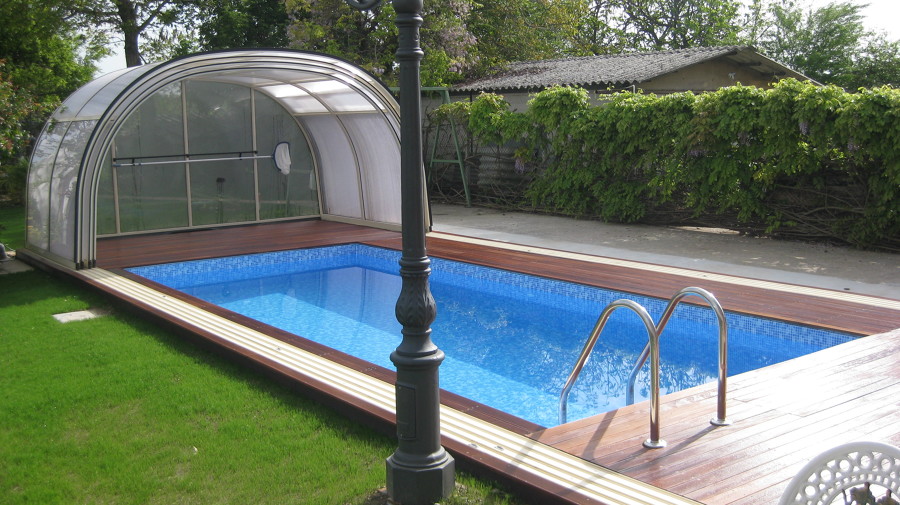 Piscina interrata con deking e copertura .