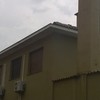 Pulizia grondaie su tetto edificio motel a 1 piano